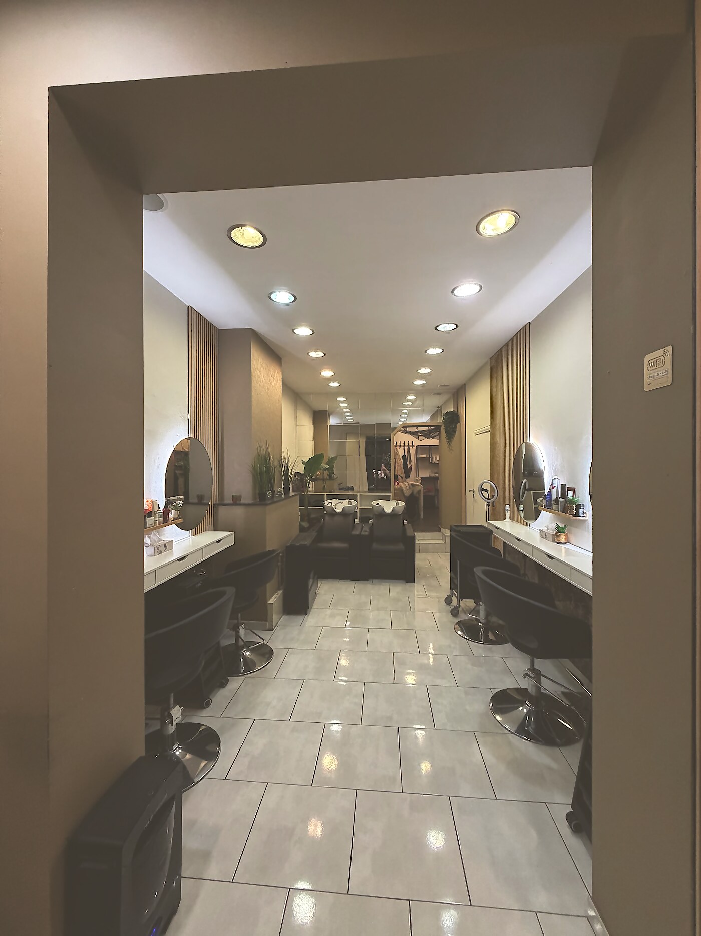 L'intérieur du salon HAIR'itage à Nivelles : postes de coiffage et miroirs